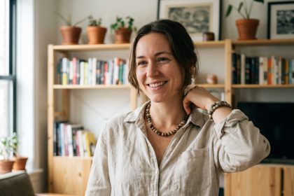 Femme ajustant un collier en pierres naturelles dans un salon cosy